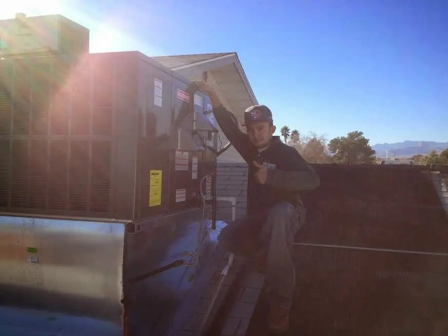 HVAC technician performing Boiler Repair on a rooftop unit in Ontario